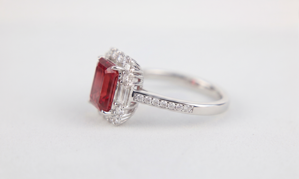 Bague ornée d'une pierre précieuse taille émeraude avec double halo et anneau pavé