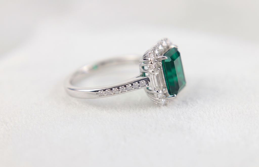 Bague ornée d'une pierre précieuse taille émeraude avec double halo et anneau pavé